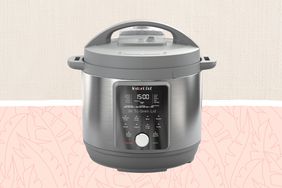 One of the best pressure cookers, the Instant Pot, on a pink and tan patterned background.