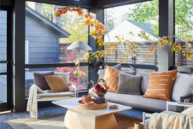 a warm screened in porch with wood beams and fall leaves as decor